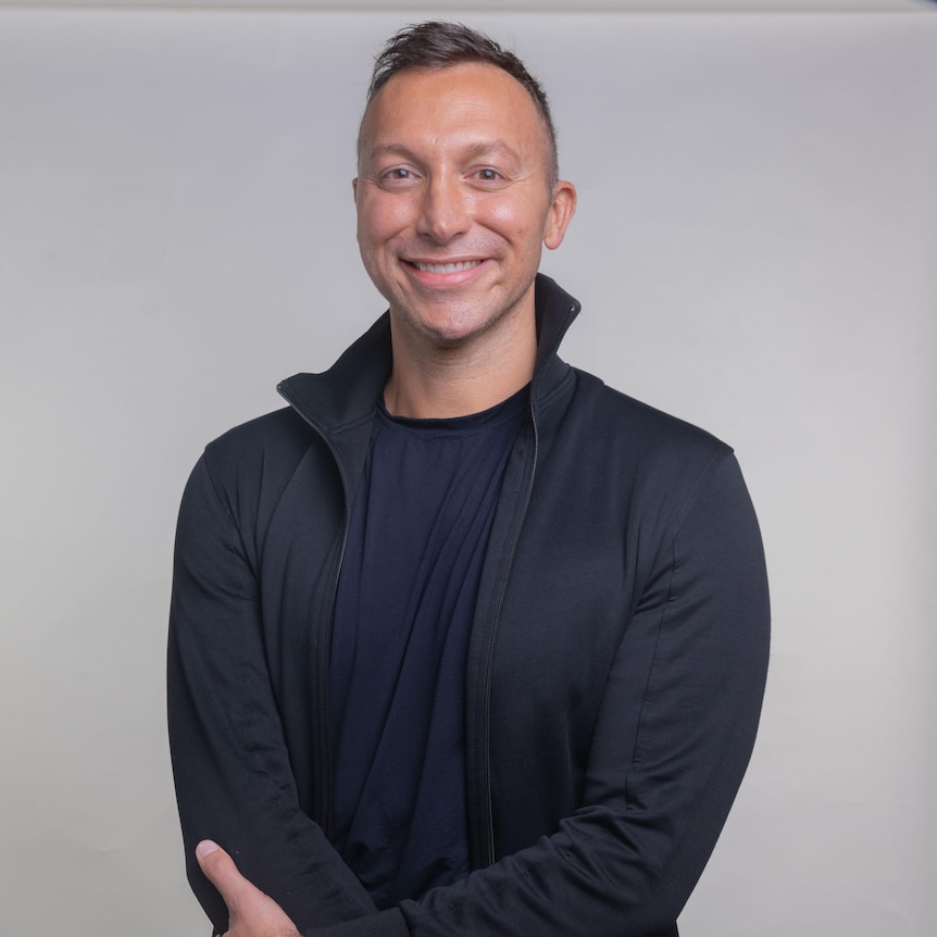 Ian Thorpe smiling with a large geometric window behind him.