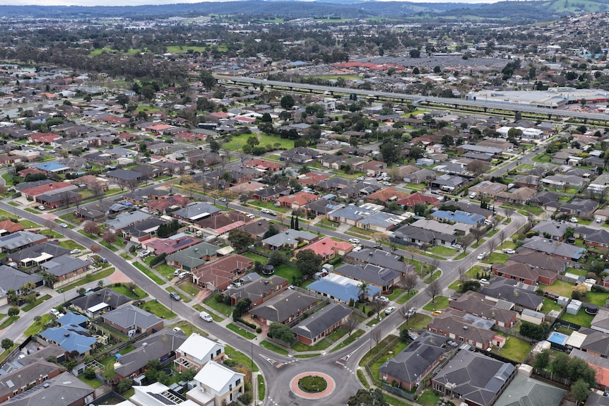 Suburban homes are seen from above in a drone shot.