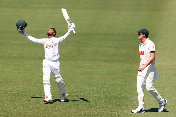 Pat Cummins of Australia looks on as Tanzid Hasan of Bangladesh celebrates after scoring a century.