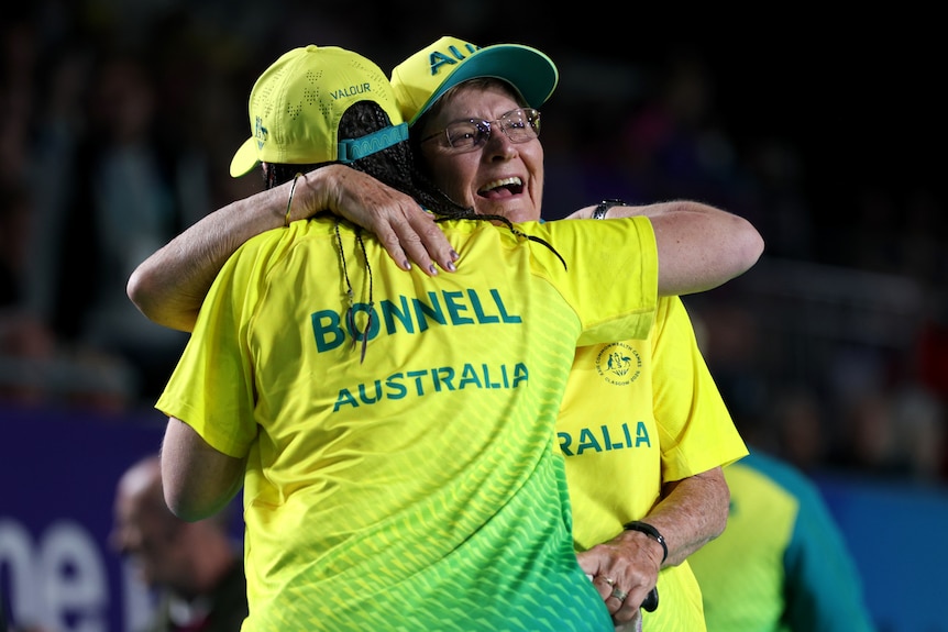 Bowls gold medallists Serena Bonnell and Louise Hopkins hug after winning bowls gold.