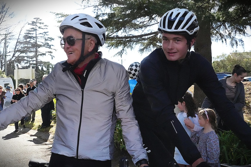 Cyclists waving to crowd