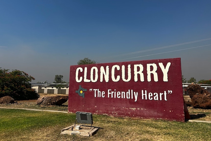 A dark red sign that says cloncurry "the friendly heart".
