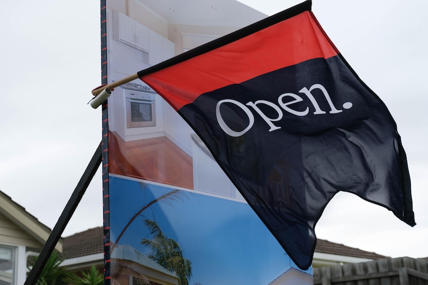 An open home flag flaps in the wind.