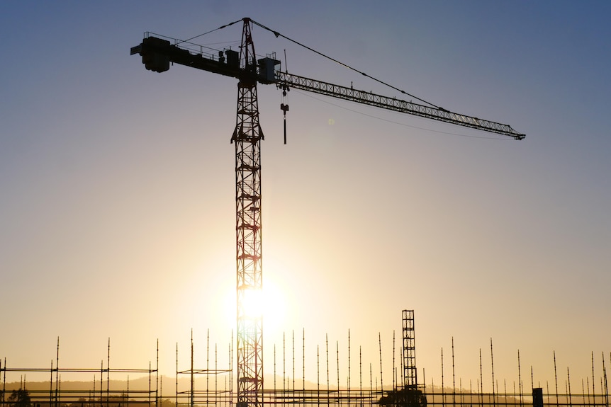 A tall construction crane pictured at sunset on the Gold Coast