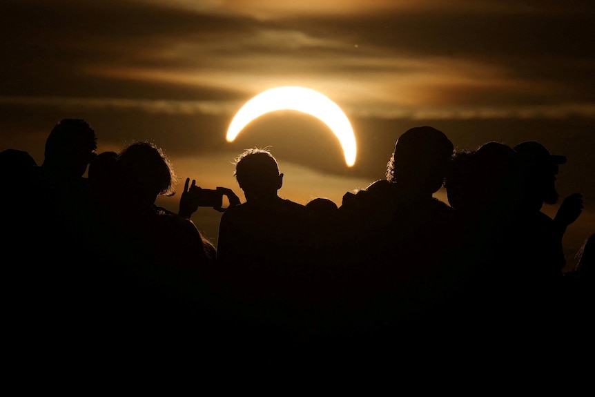 A group photograph a crescent moon eclipse.