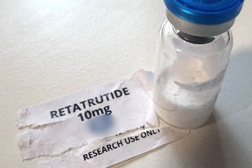 A vial of liquid sitting on a table with a label saying 'retatrutide 10mg'