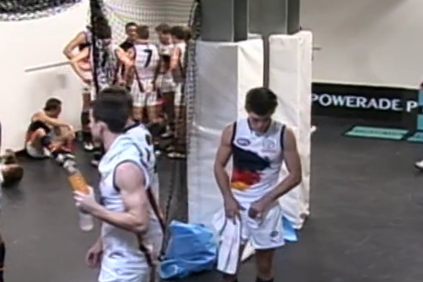 A man in a football uniform prepares to adjust his shorts