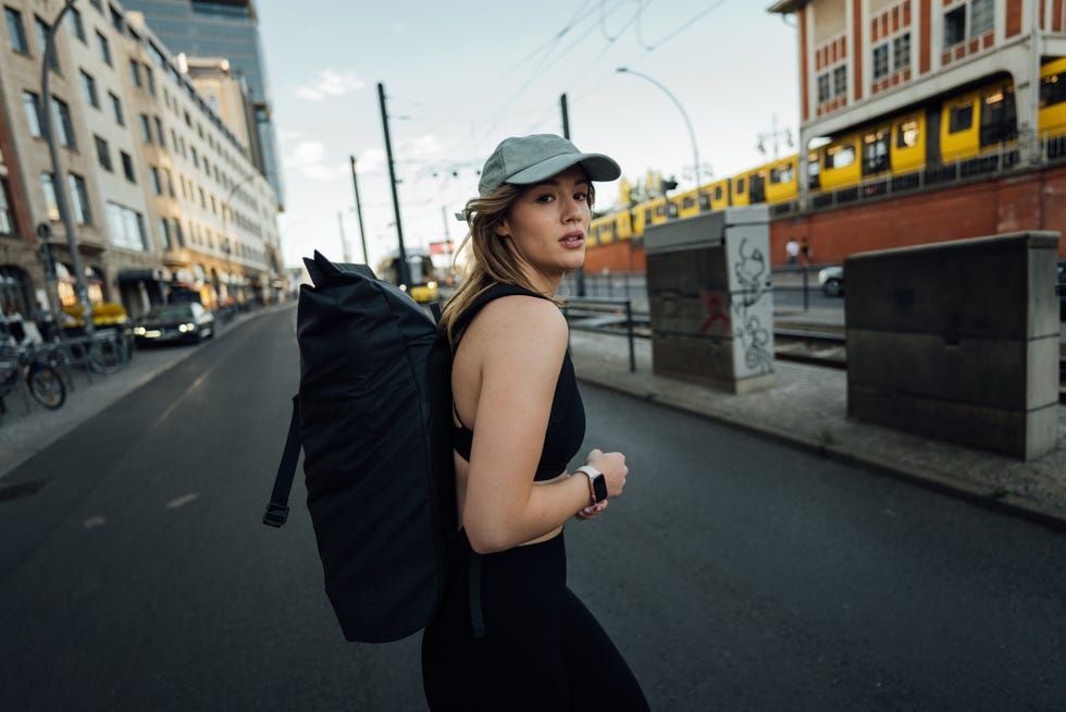 Woman crossing street in Berlin with backpack