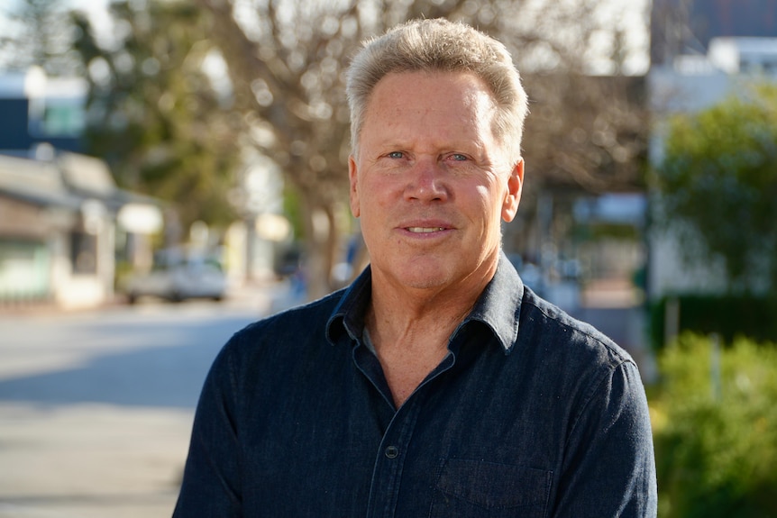 A middle-aged man looks straight at the camera.