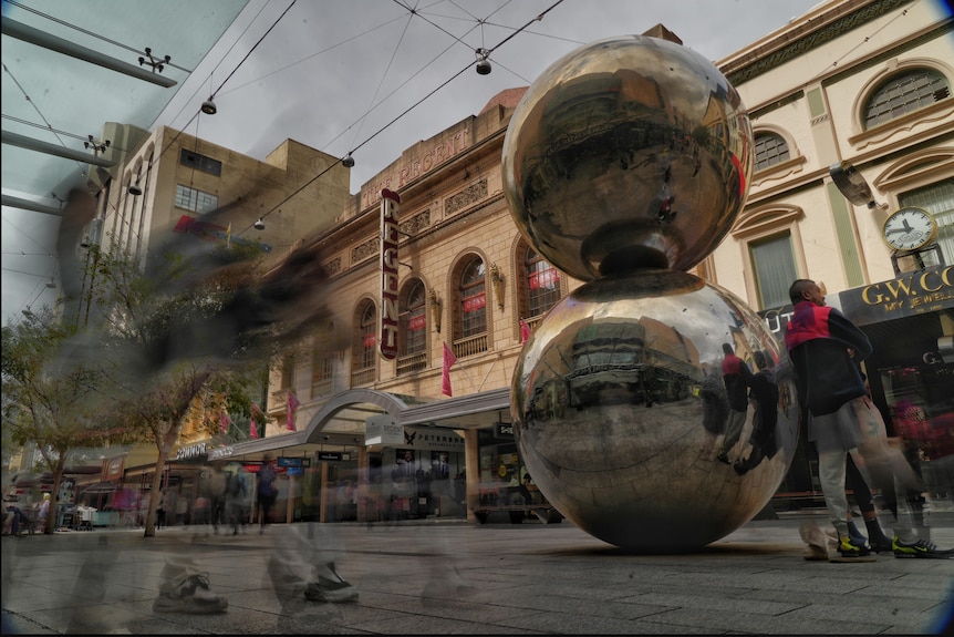 The Malls Balls with shops in the background and the blur of shoppers walking by