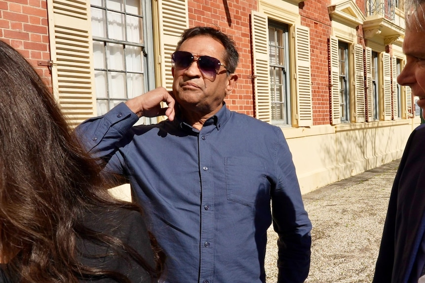 Nicky Winmar scratches his neck standing outside court