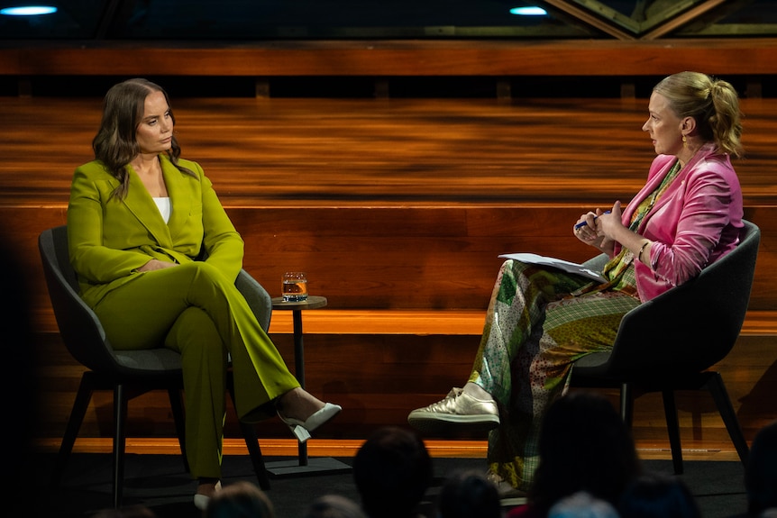 Jelena Dokic and Leigh Sales sit on a timber stage, chatting.