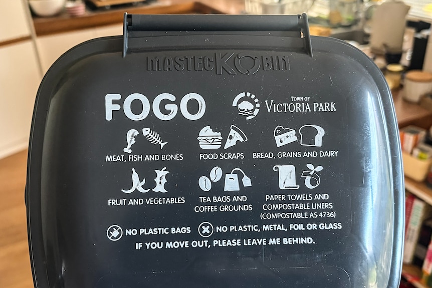 Lid of small grey kitchen bin with list of allowed items