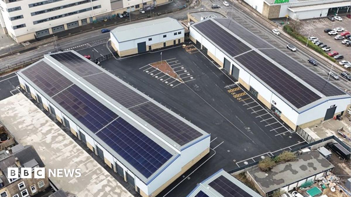 An aerial shot of a business park, with large white warehouse-style buildings surrounded by roads and car parks.