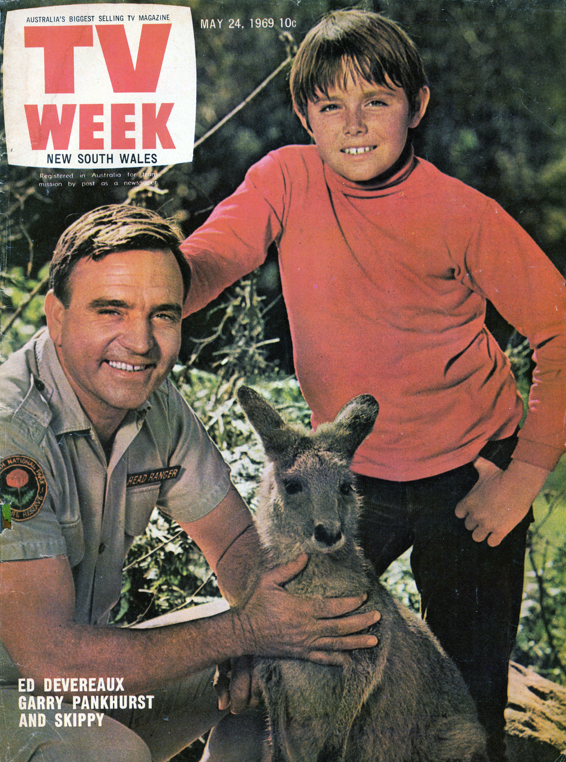 A magazine cover featuring two actors, one older, one a boy, outside next to a kangaroo.