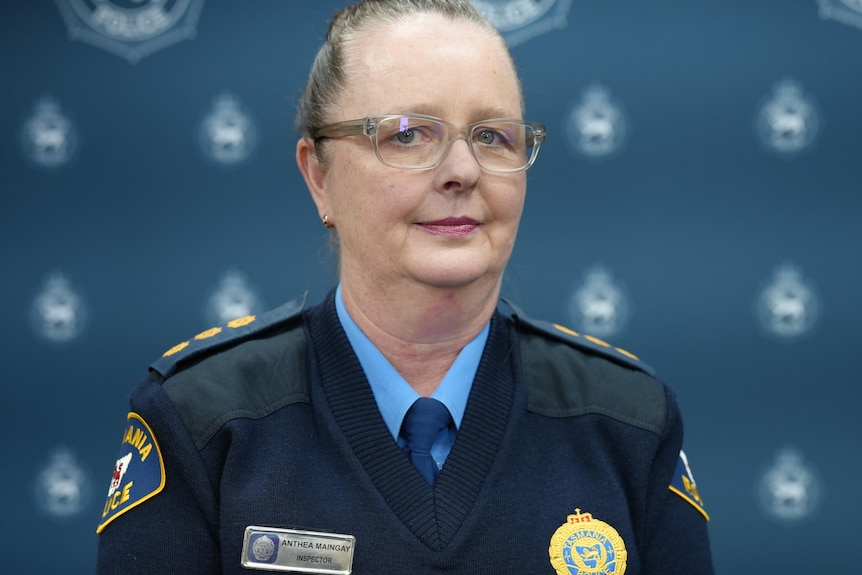 A policewoman in uniform wearing glasses