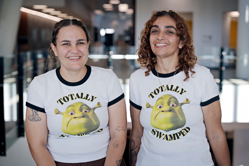 Skye and Bobby Lockyer standing together smiling, wearing a white tshirt with shrek on it which reads 'totally swamped'