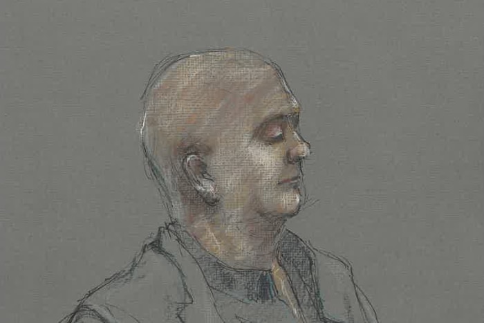 A sketch of a bald middle aged man with his eyes closed wearing dark clothing.