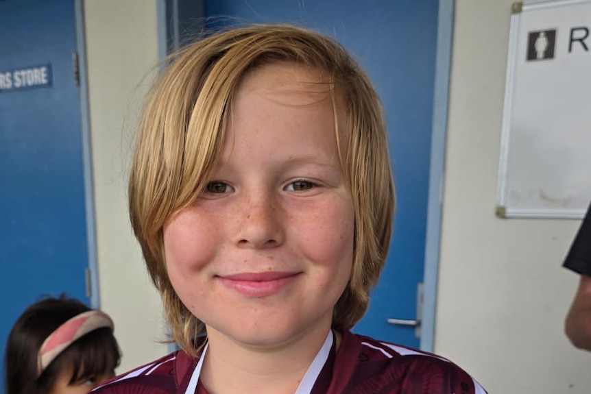 A 10-year-old boy in a sports jersey.