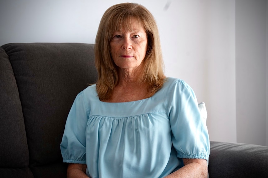 A strawberry blonde haired woman in a blue shirt.