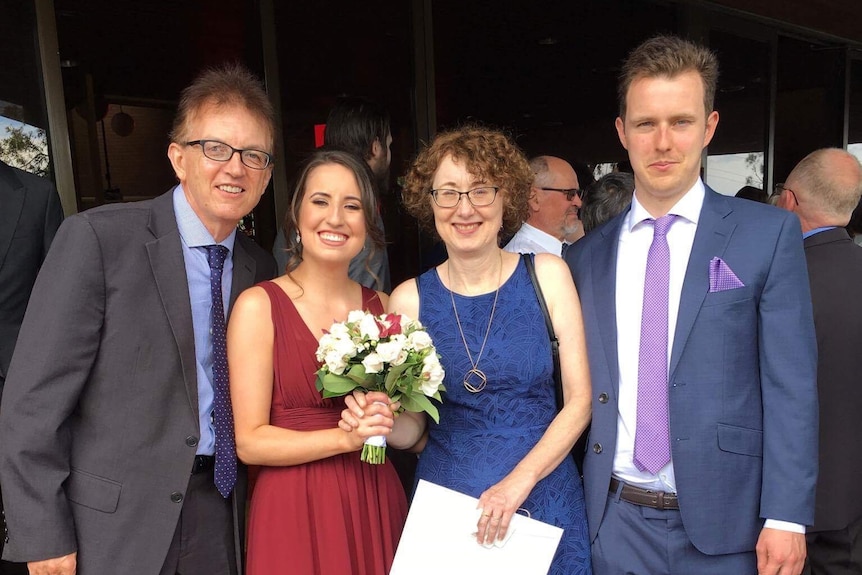 A family of four smiling.