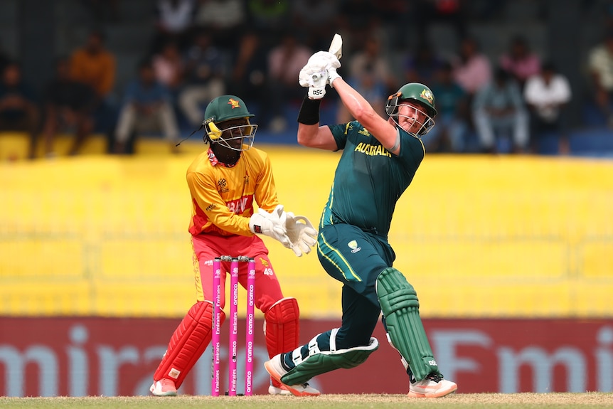 Matthew Renshaw of Australia plays a shot as Tadiwanashe Marumani of Zimbabwe keeps
