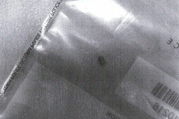 A black and white photo of a air rifle pellet in a police evidence bag