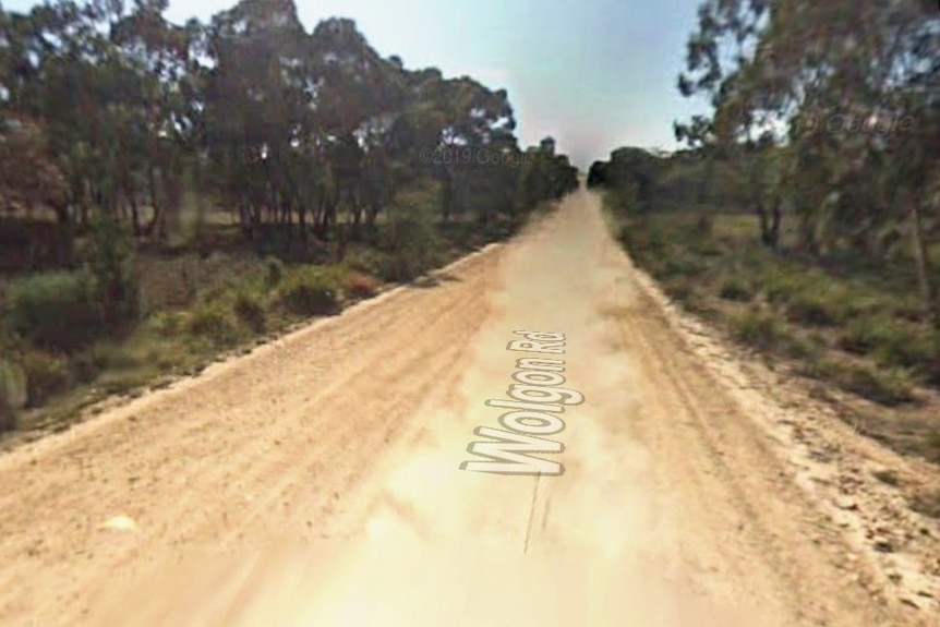 Empty dirst road with bush at edges and Wolgon Rod title.