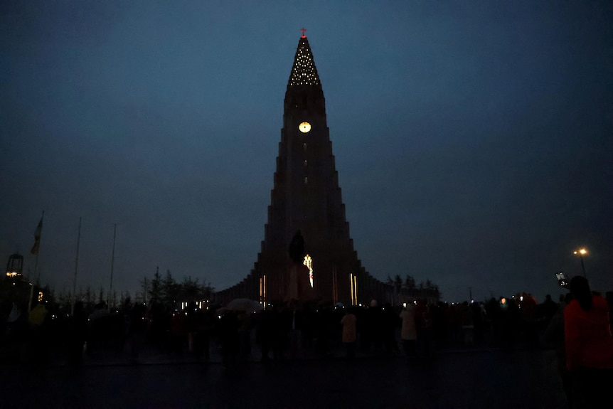 A clock tower in under dark skies.