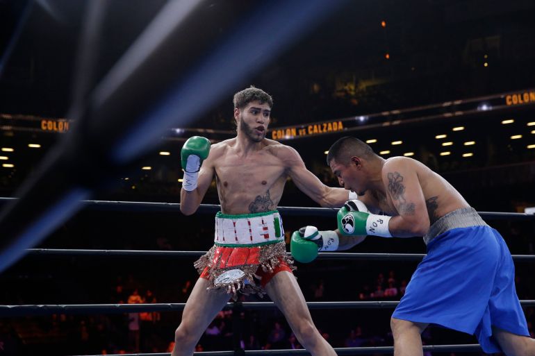 Prichard Colon, left, exchanges punches with Daniel Calzada during a junior middleweight title boxing match, Saturday, April 11, 2015, at New York