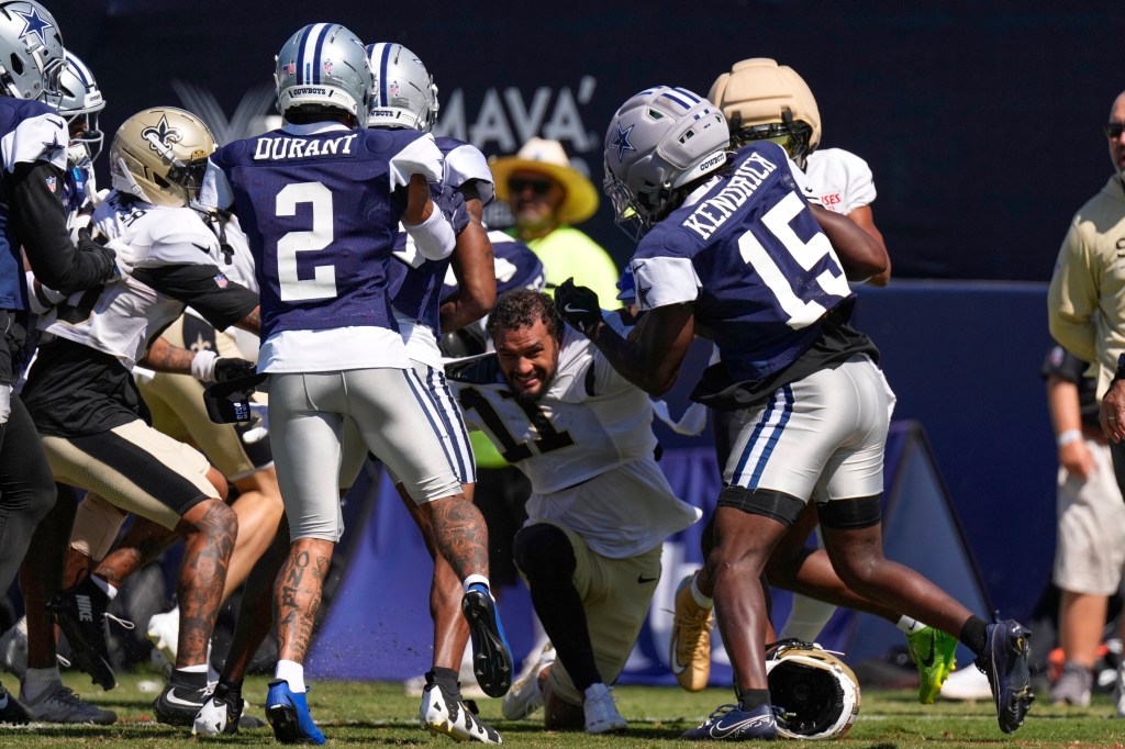 New Orleans Saints wide receiver Ronnie Bell, center, fights with members of the Dallas Cowboys, including safety Cobie Durant (2) and cornerback Derion Kendrick (15) during an NFL football joint practice, Tuesday, Aug. 18, 2026, in Oxnard, Calif.