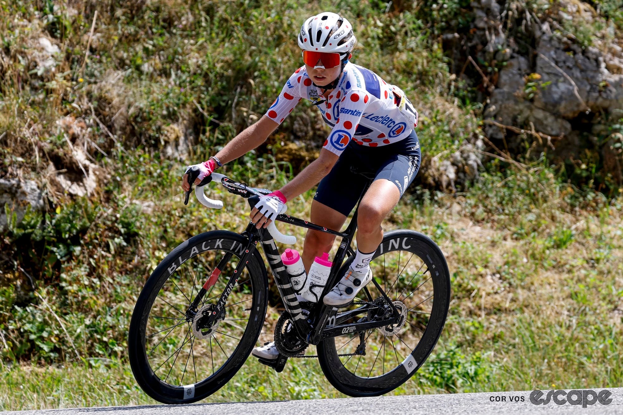 Mahe leans into a turn wearing the polka dot jersey and matching helmet.