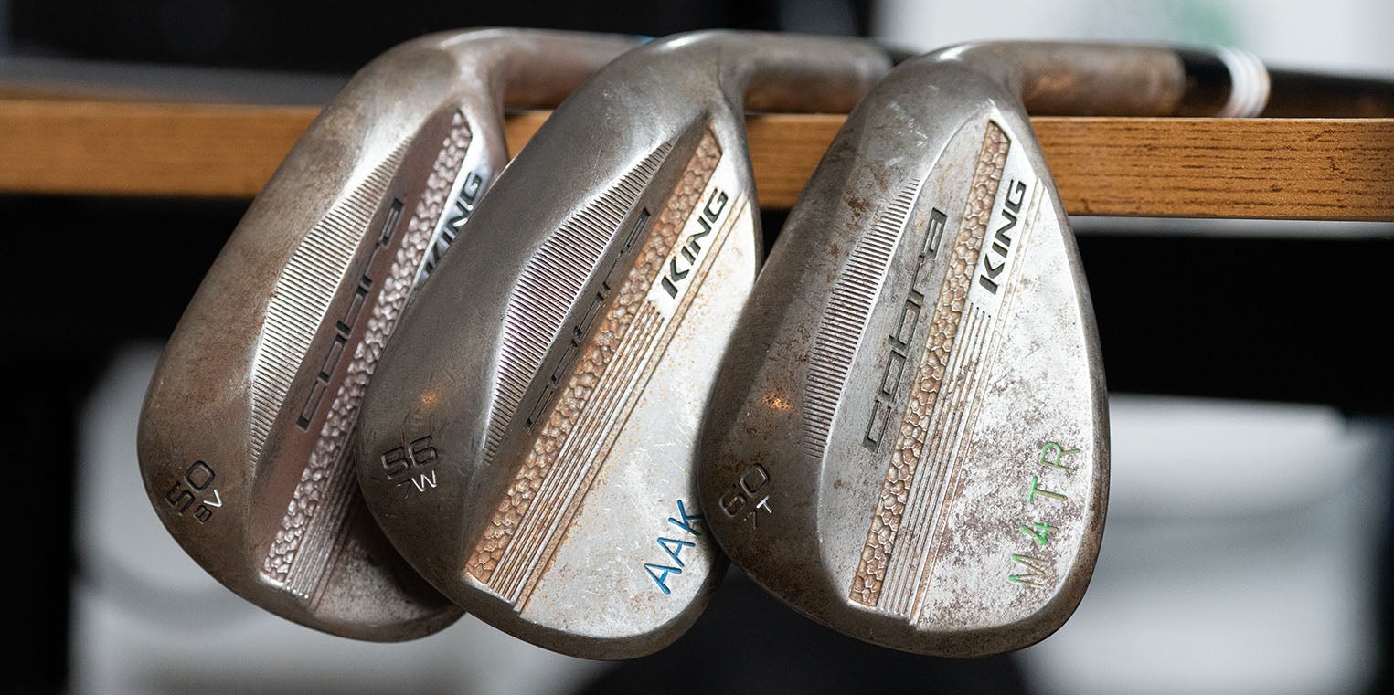 Three worn Cobra King golf wedges with visible loft numbers (52, 56, 60) and engraved initials rest against a wooden surface, showing signs of frequent use and some rust—classic evidence that these once made the perfect wedges for any golfer. Ready to be Fully Fit 2026.