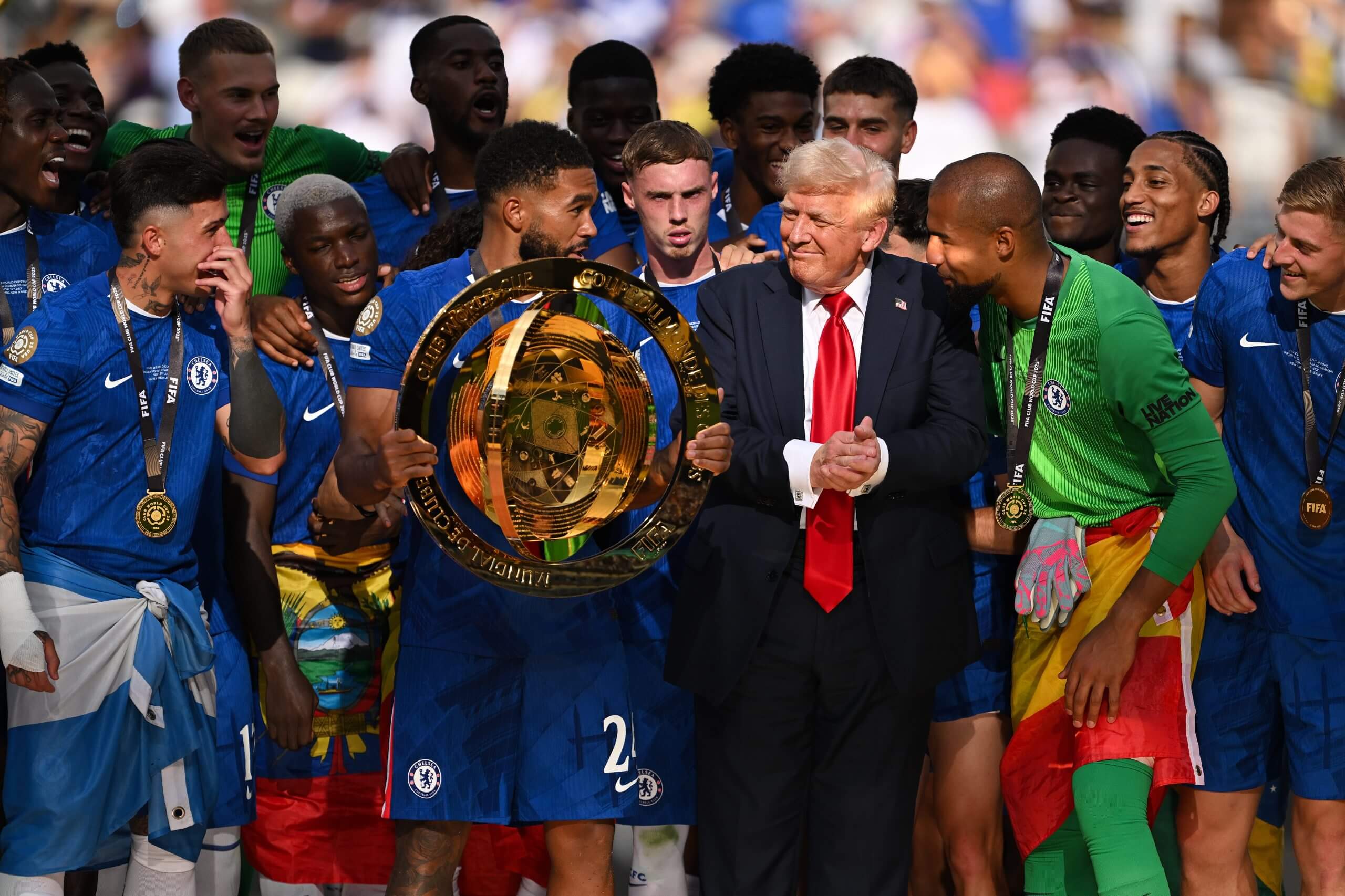 Reece James holds the Club World Cup trophy, flanked by Donald Trump, in 2025