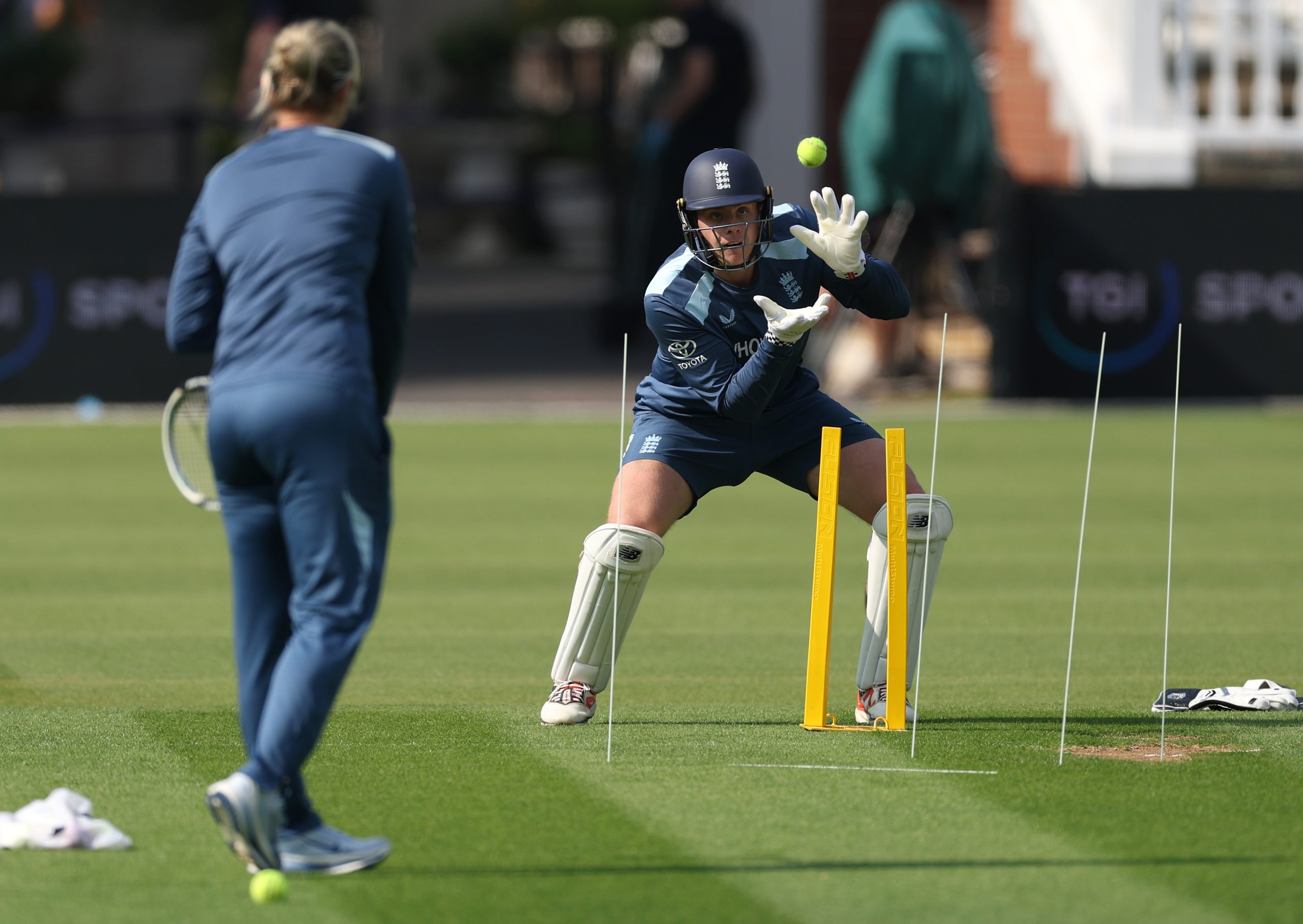Fielding coach Sarah Taylor smashes a tennis ball at Jamie Smith in practice