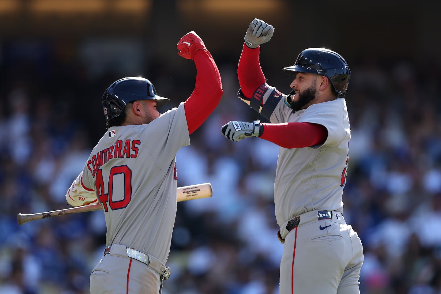 Willson Contreras (left) welcomes Wilyer Abreu, who hit a home run in the third inning at Dodger Stadium on Sunday.