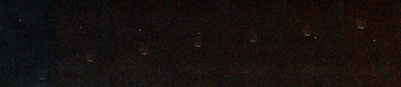 A grainy black image showing a horizontal sequence of seven faint crescent shapes evenly spaced from left to right. A tiny bright white dot moves diagonally from the upper left to the lower right, appearing to pass behind the crescent shapes.