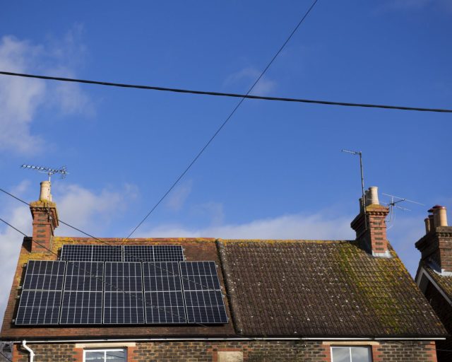 A large array of Solar panels which provide the renewable energy sit on the roof of a house in Horsham UK