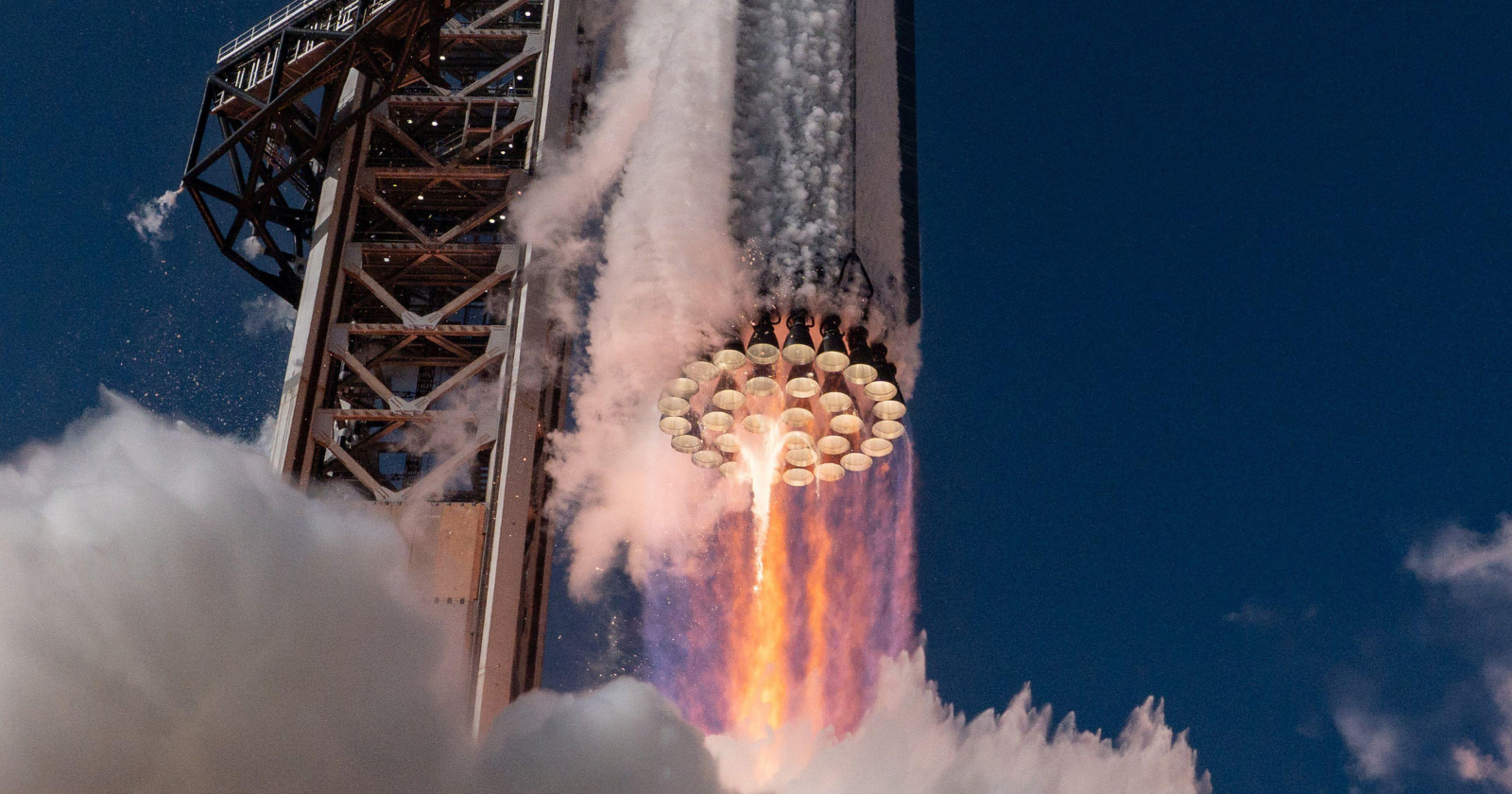 Starship's 33 engines push down with 74,400 kilonewtons at liftoff — roughly twice the force of the Saturn V that sent humans to the Moon, yet the whole vehicle is designed to be caught like a falling pencil and flown again the next day
