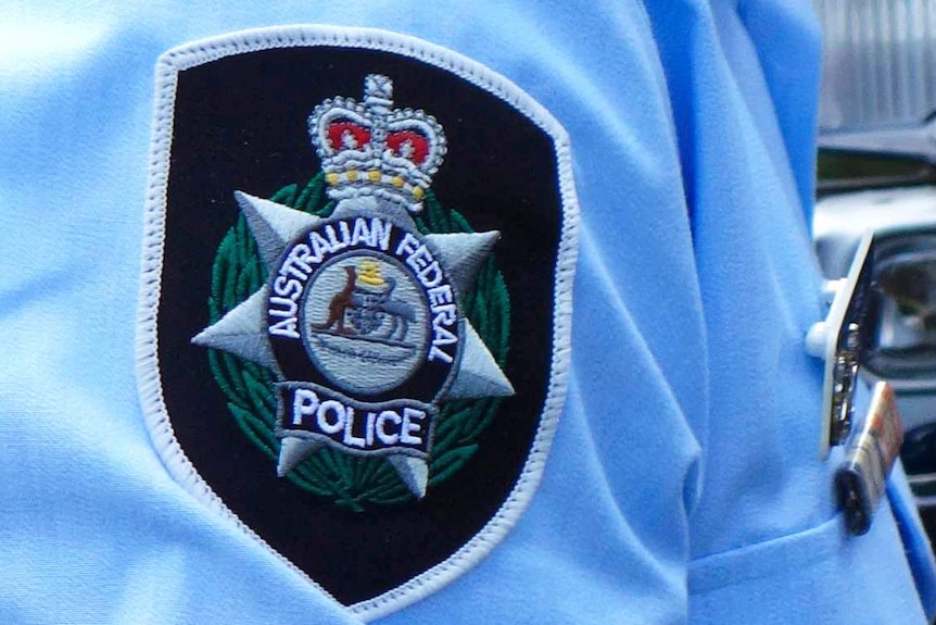 The Australian Federal Police insignia on the shoulder of an officer's shirt.
