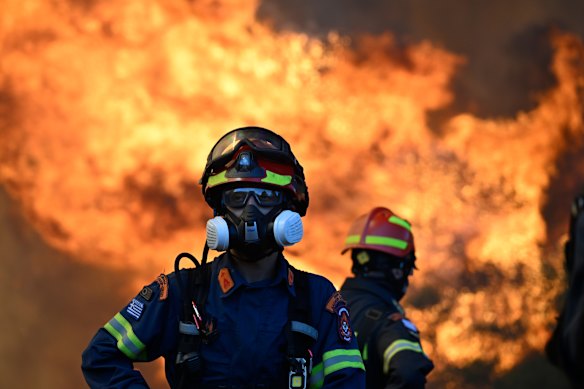 A firefighter stands as flames rising during a wildfire near Porto Germeno, north-west of Athens, on Sunday.