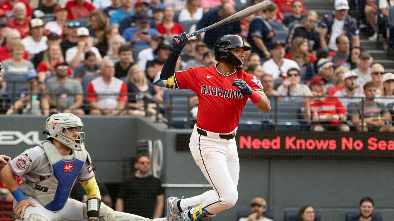 Cleveland Guardians' Angel Genao watches his single off New York Mets starting pitcher Christian Scott, his first Major League hit, as Francisco Alvarez looks on during the third inning of a baseball game, Wednesday, Aug. 5, 2026, in Cleveland. (AP Photo/Phil Long)