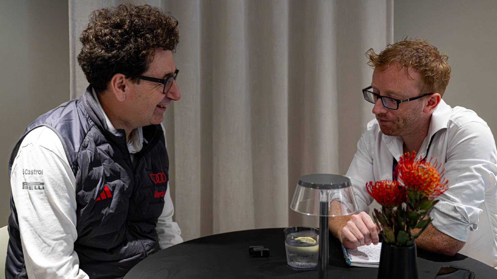 Audi's Mattia Binotto pictured in conversation with Thomas Maher at the 2026 Belgian Grand Prix.
