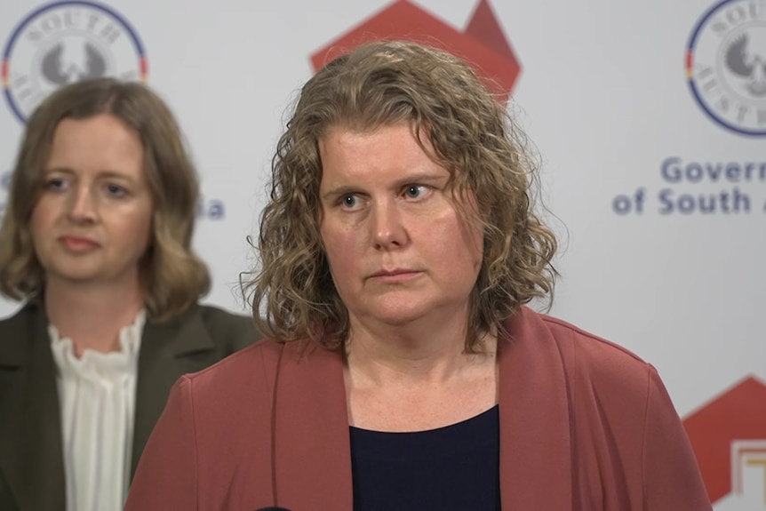 Two women in front of South Australian state logo
