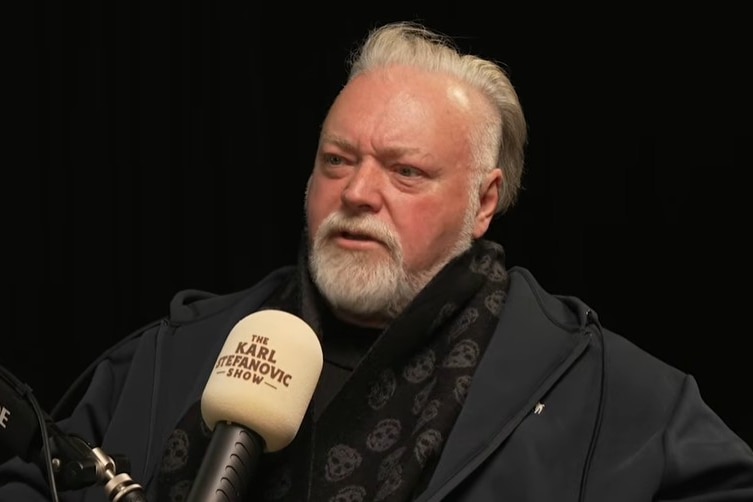 Kyle Sandilands sits behind a microphone during an interviw on karl stefanovic's podcast on youtube.