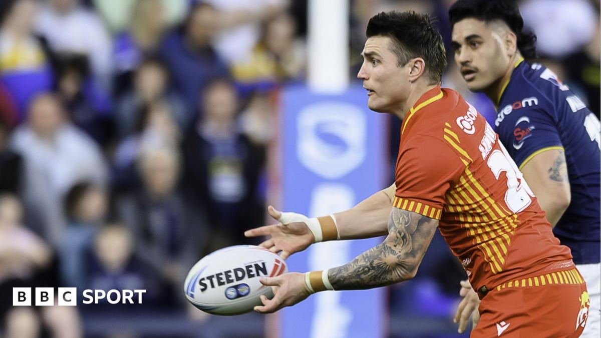Zac Lipowicz throws a pass wearing a red Catalans Dragons kit