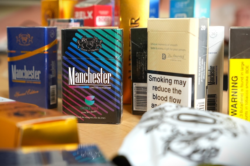Packets of illegal cigarettes displayed on a table.