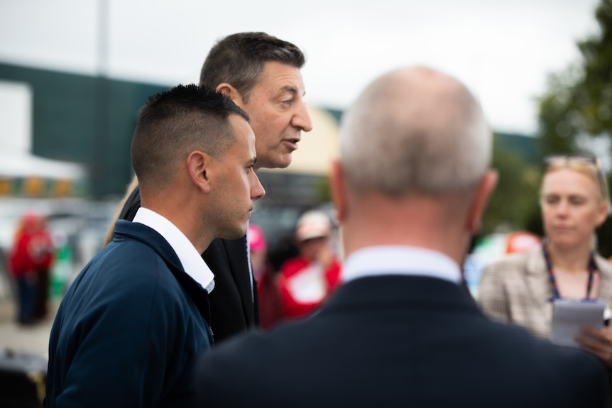 Ryan Robertson listens to Basil Zempilas at a press conference.