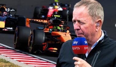 Brundle holding Sky Sports mic looking over Ferrari, Red Bull and McLaren F1 cars on track