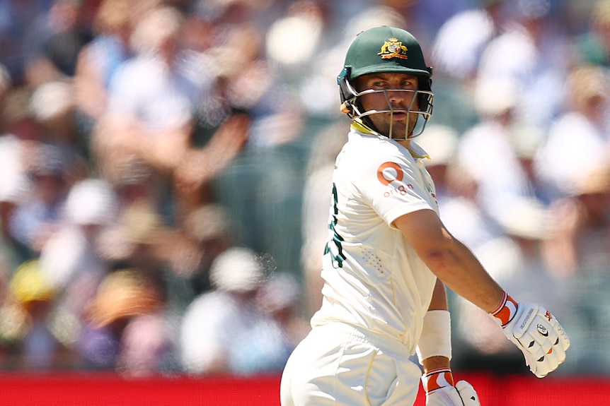 Australia batter Josh Inglis looks back over his shoulder as he bats in a cricket Test.